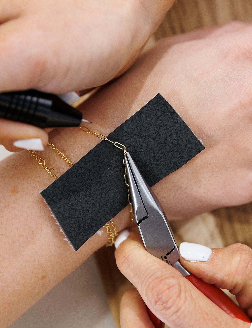 A delicate 14K gold filled bracelet is welded on at one of Linked by Taylor's pop-up events.