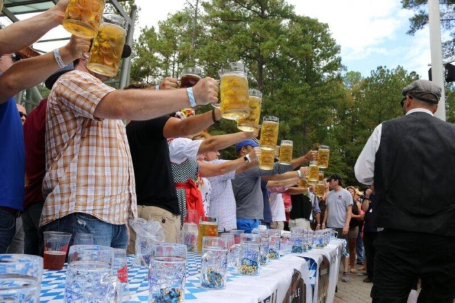 Stein hoisting competitors hold steins of beer